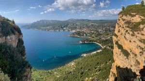 Scogliera rossa di Cap Canaille vista dal mare con cielo azzurro estivo