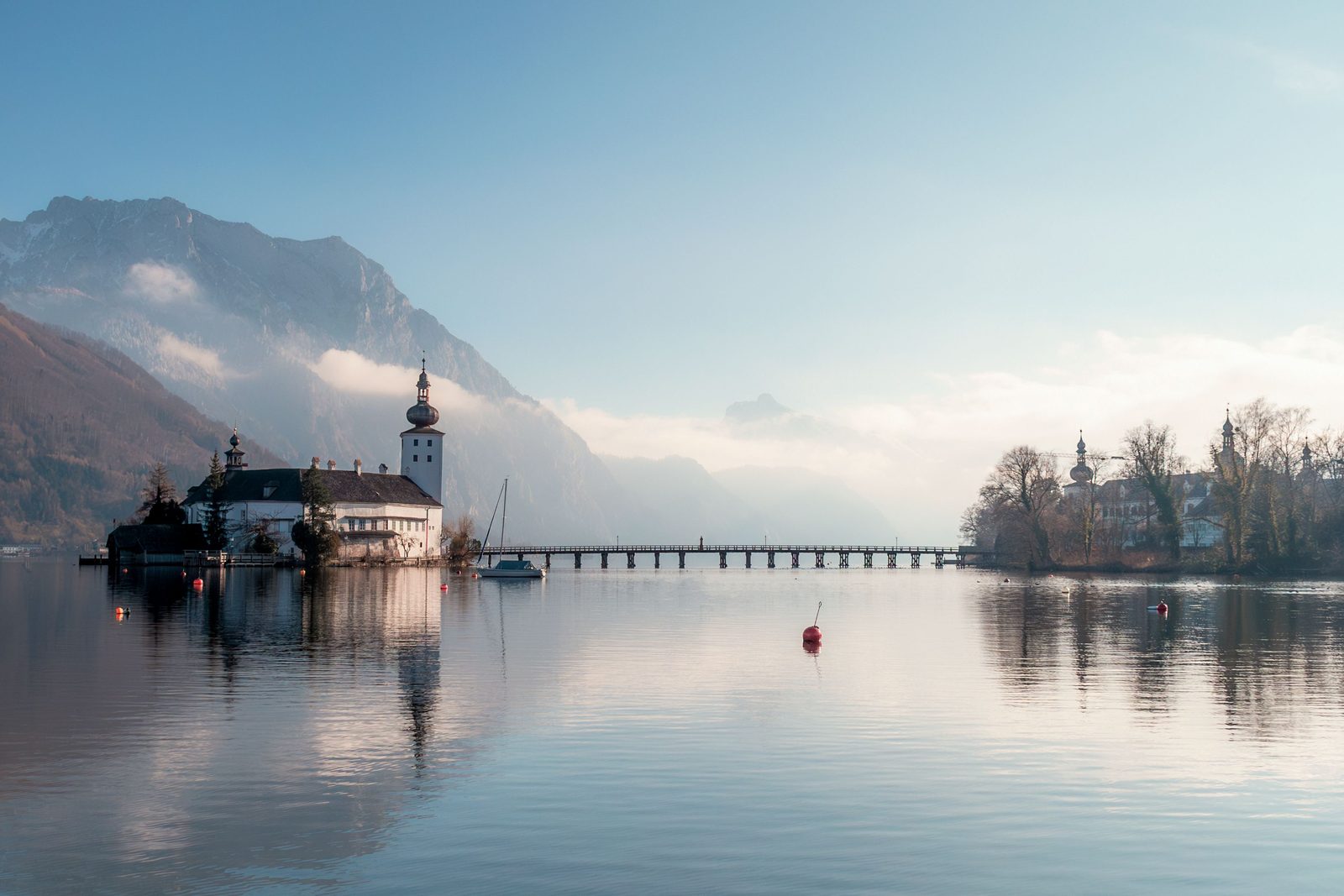Riflesso del castello Schloss Ort sul lago di Traun al mattino con le Alpi sullo sfondo Riflesso del castello Schloss Ort sul lago di Traun al mattino con le Alpi sullo sfondo