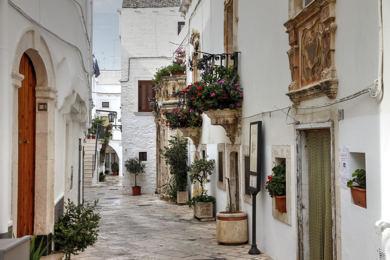 Vicolo bianco del centro storico di Ceglie Messapica con vasi di fiori Vicolo bianco del centro storico di Ceglie Messapica con vasi di fiori