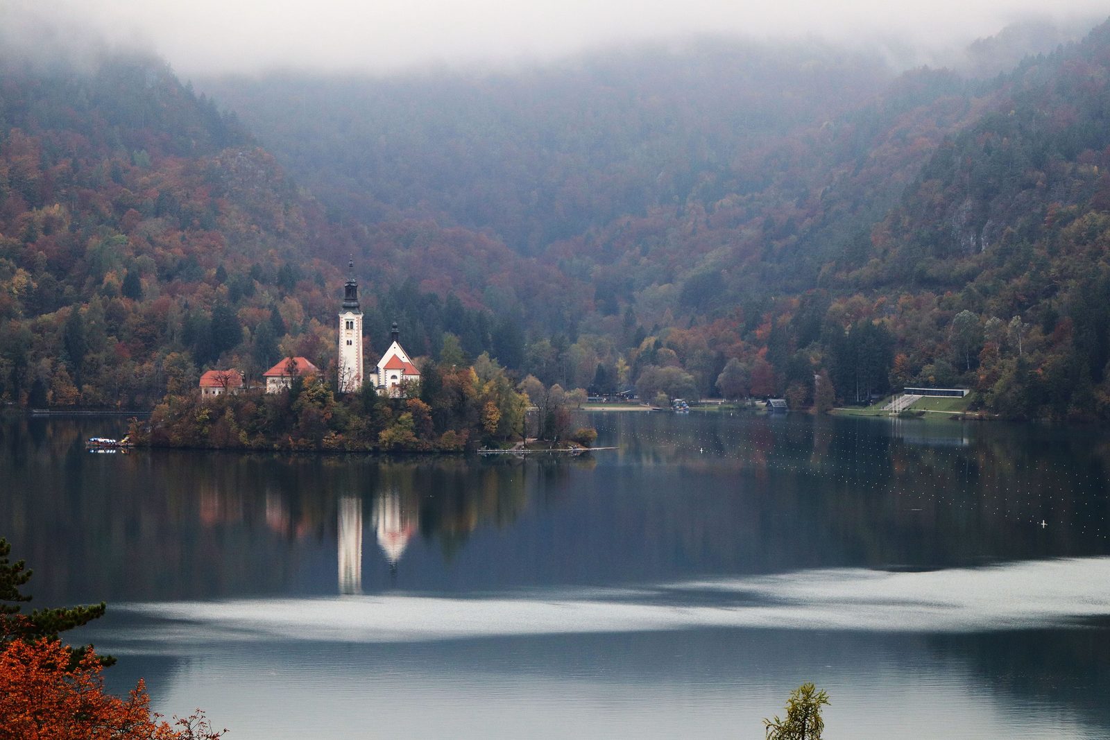 Lago di Bled in autunno con foliage e isola riflessa sulla superficie