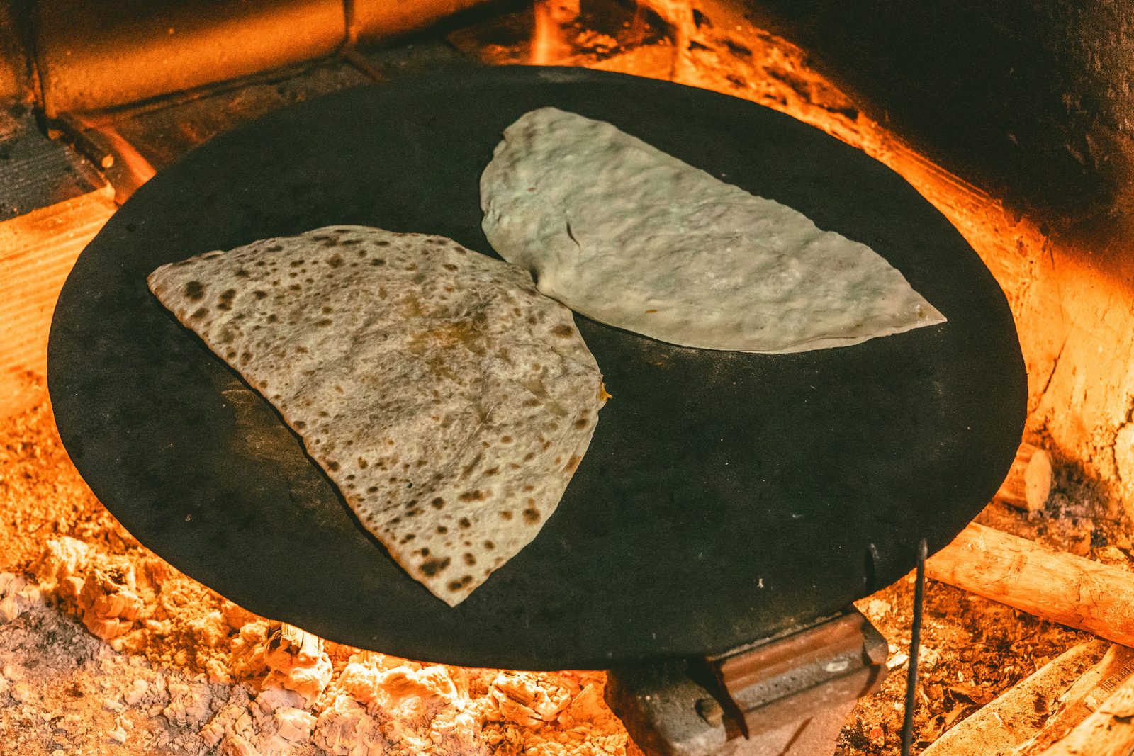 Piadina romagnola appena cotta su testo di terracotta con squacquerone e rucola Piadina romagnola appena cotta su testo di terracotta con squacquerone e rucola