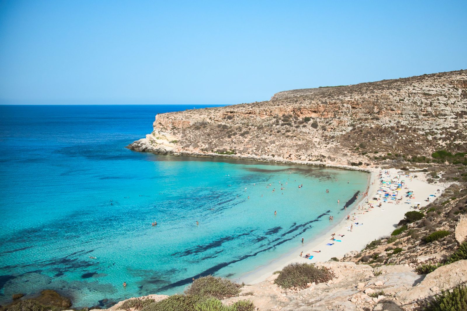 Spiaggia dei Conigli a Lampedusa con sabbia bianca e mare azzurro turchese trasparente Spiaggia dei Conigli a Lampedusa con sabbia bianca e mare azzurro turchese trasparente