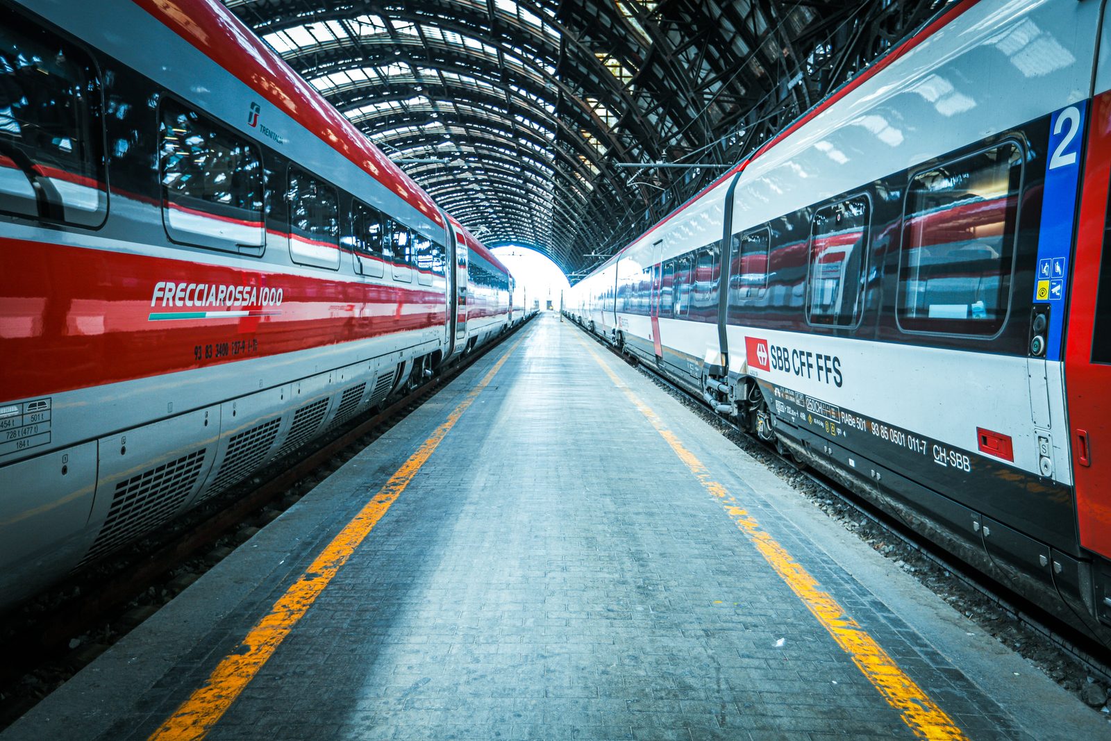 Stazione di Milano Centrale con treni in partenza nella luce diurna Stazione di Milano Centrale con treni in partenza nella luce diurna
