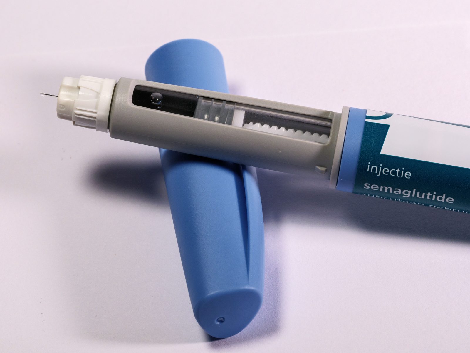 Penna per insulina e siringhe su sfondo bianco clinico