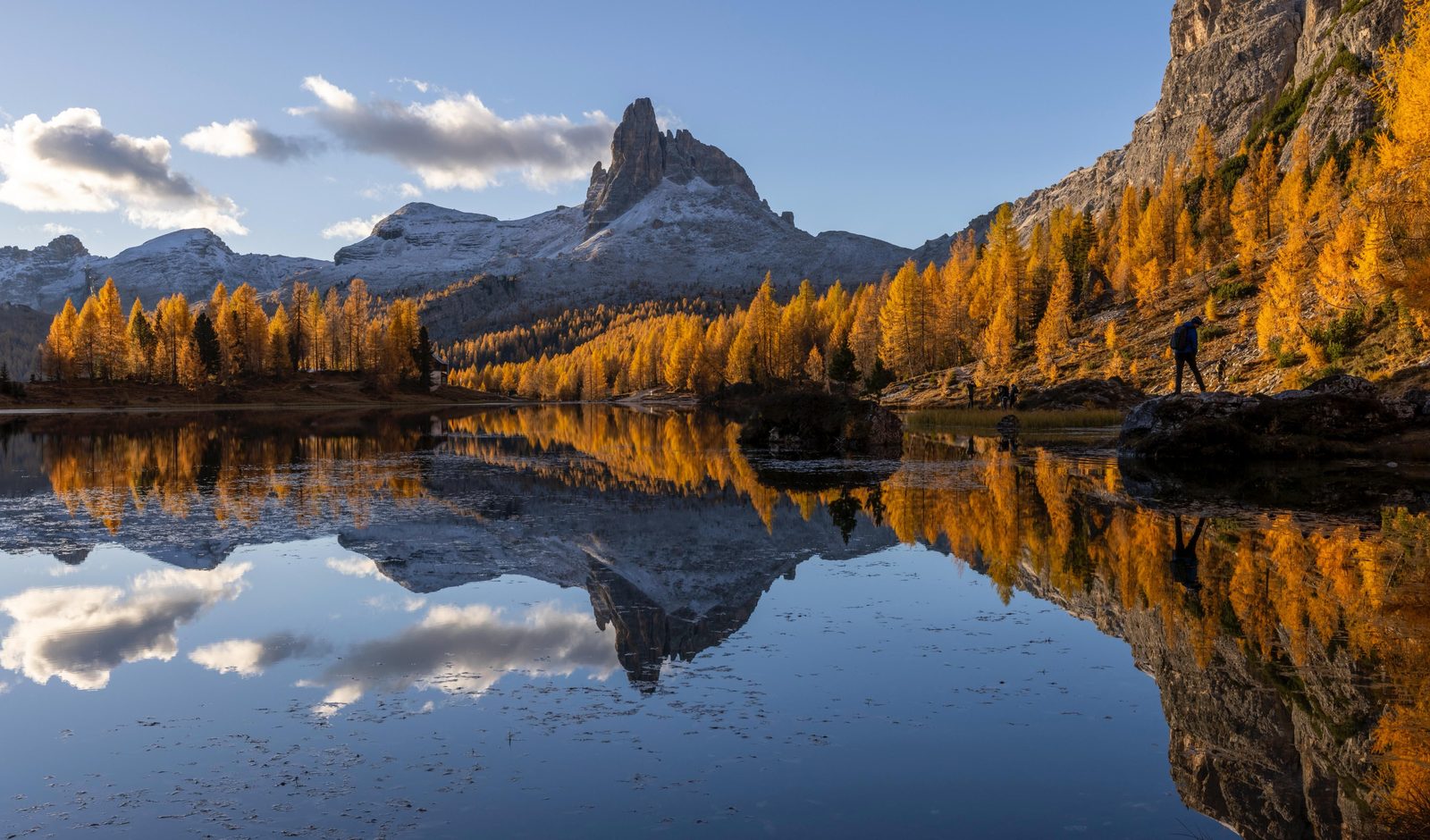 Lago di Sorapis in autunno con larici dorati e riflessi turchesi nell'acqua Lago di Sorapis in autunno con larici dorati e riflessi turchesi nell'acqua