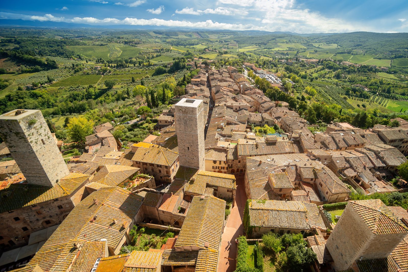 Agriturismo toscano circondato da vigneti autunnali con le torri di San Gimignano sullo sfondo Agriturismo toscano circondato da vigneti autunnali con le torri di San Gimignano sullo sfondo