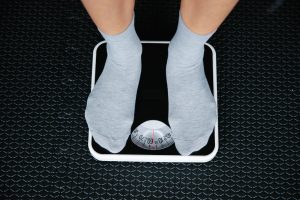 Uomo adulto sulla bilancia che monitora il peso e il metabolismo