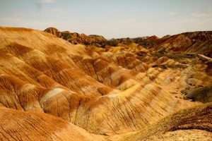 Le colline striate di rosso, arancio e giallo del geoparco Danxia di Zhangye sotto un cielo azzurro
