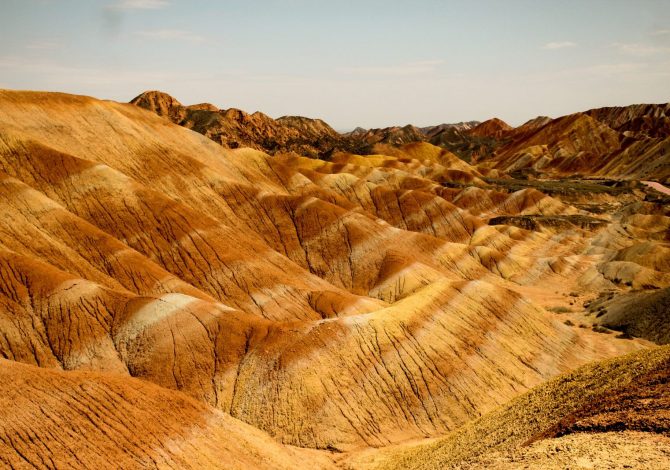Le colline striate di rosso, arancio e giallo del geoparco Danxia di Zhangye sotto un cielo azzurro